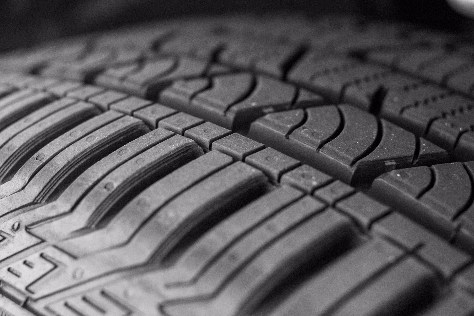 Close-up of a tire tread showing detailed pattern and texture in black and white.
